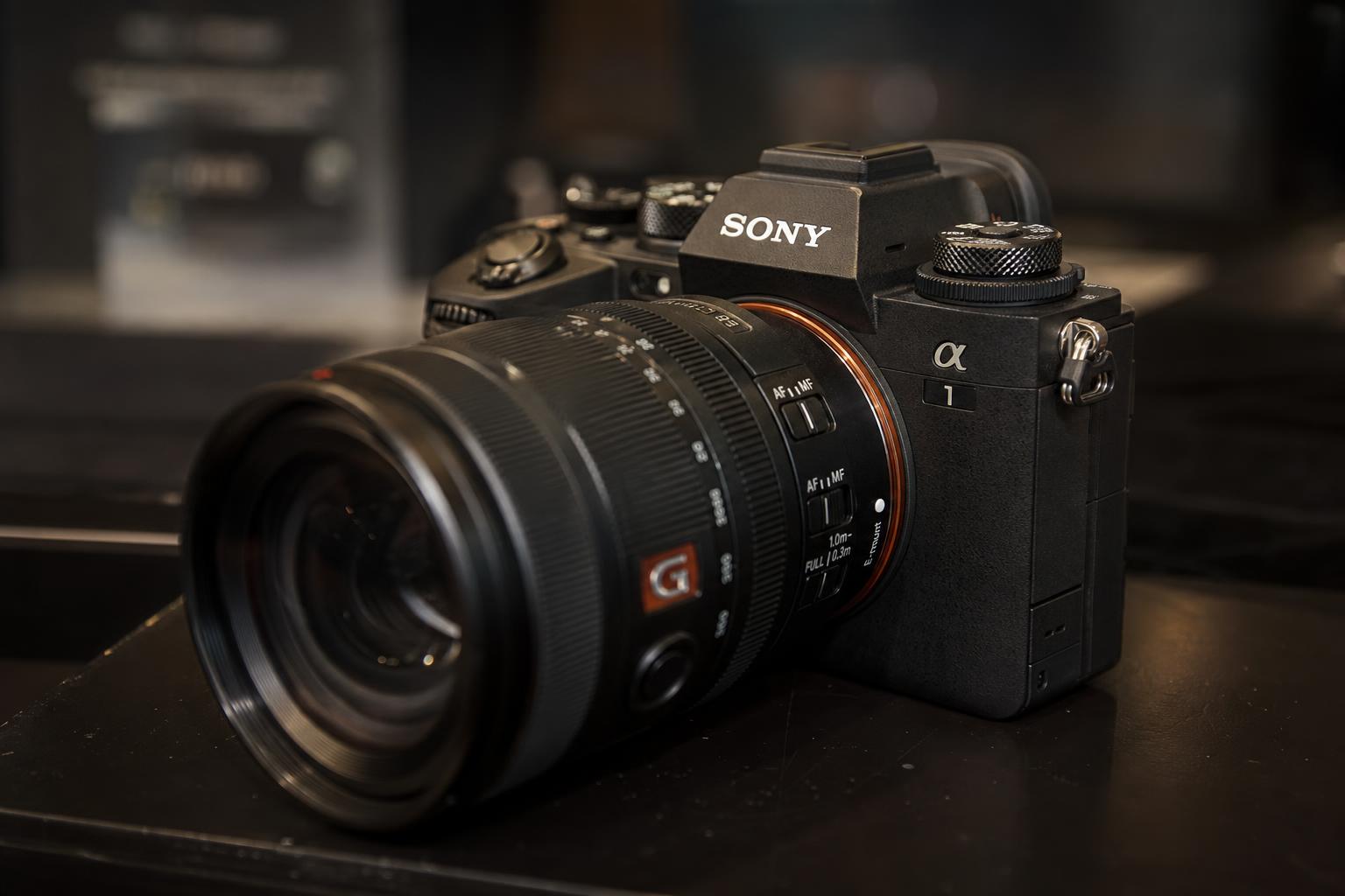 Mirrorless cameras and premium lenses on a dark display